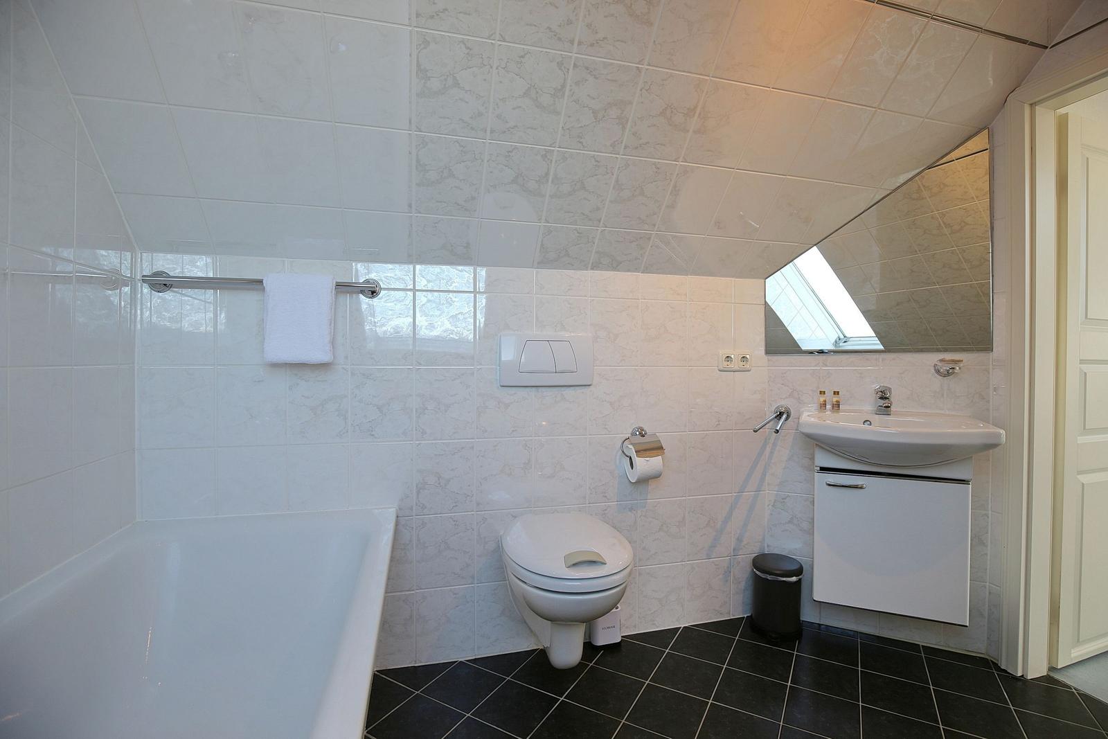 Badezimmer mit Badewanne, Toilette und Waschbecken.