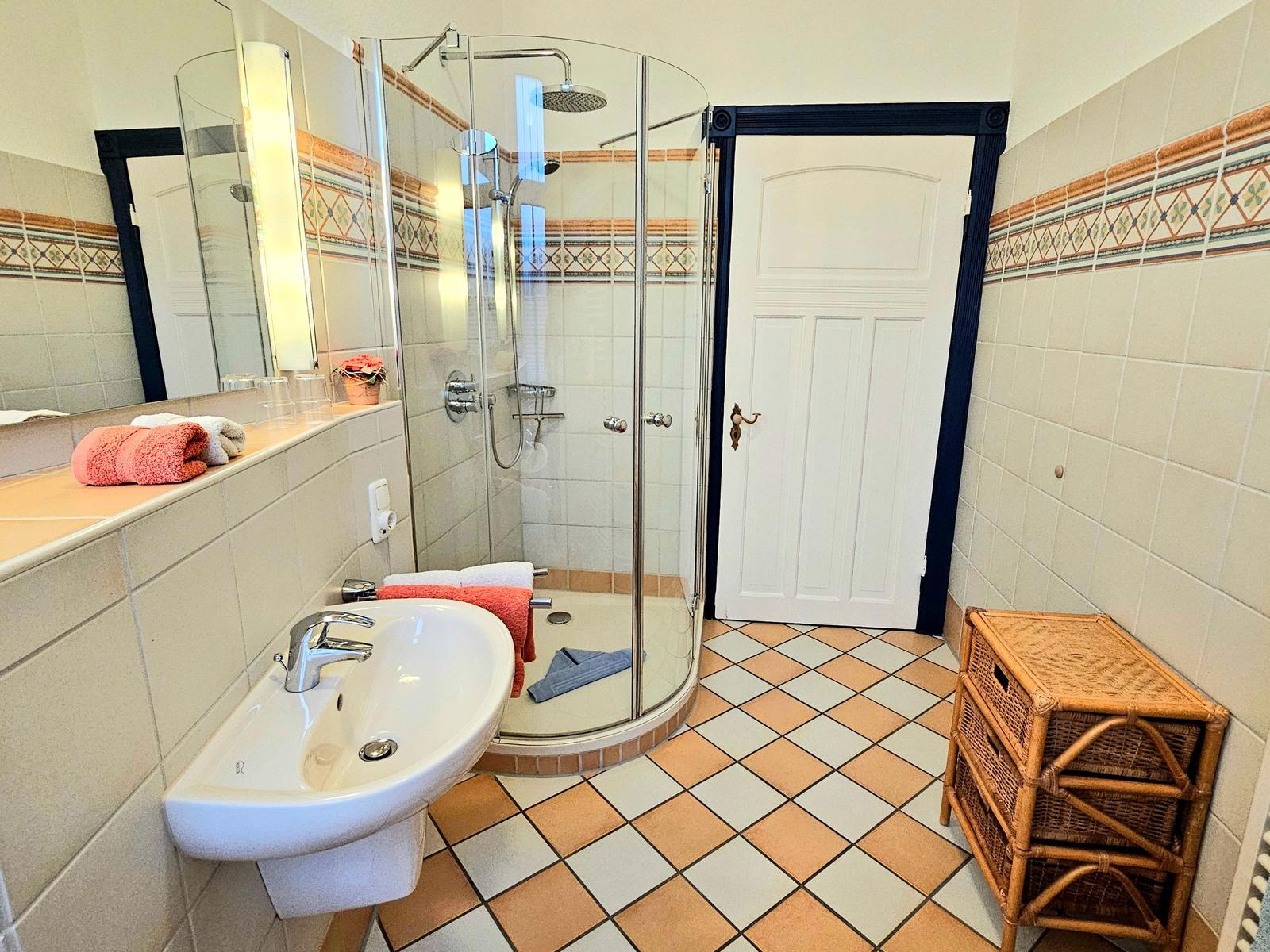 Badezimmer mit Dusche, Waschbecken und Badewanne.