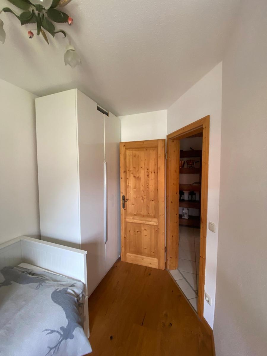 Bedroom with bed, wardrobe, and door to hallway.