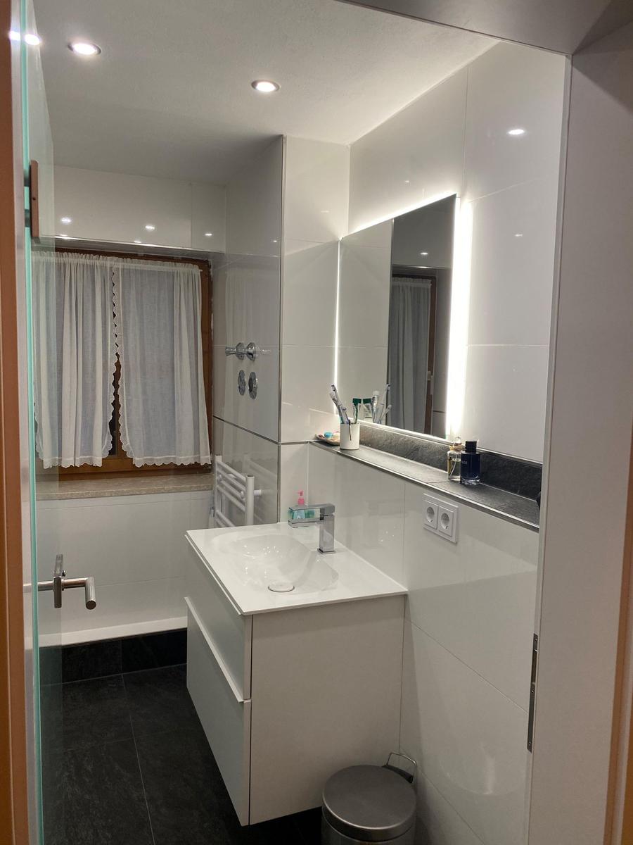 Bathroom with sink, mirror, and shower.