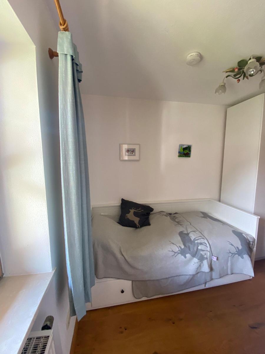 Bedroom with bed, curtain, and wooden floor