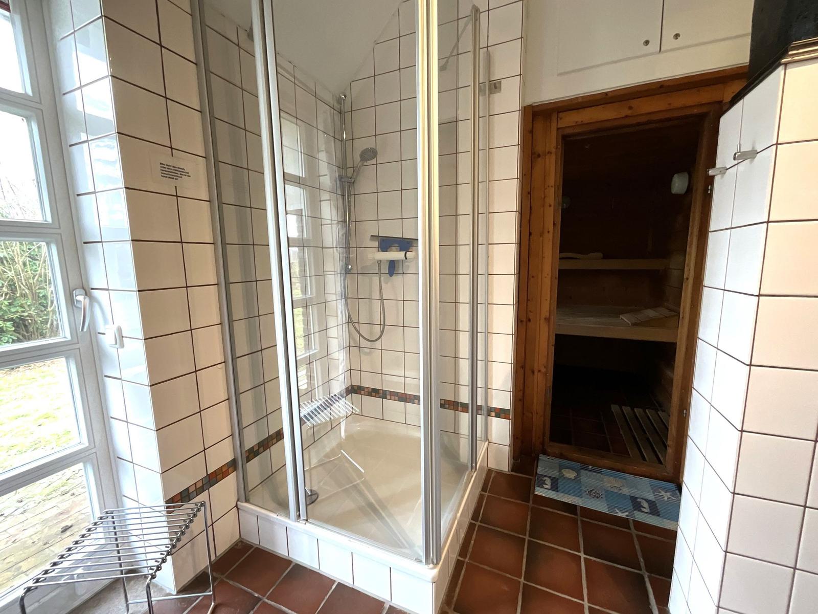 Dusche mit Glaswand und Sauna im Anschluss