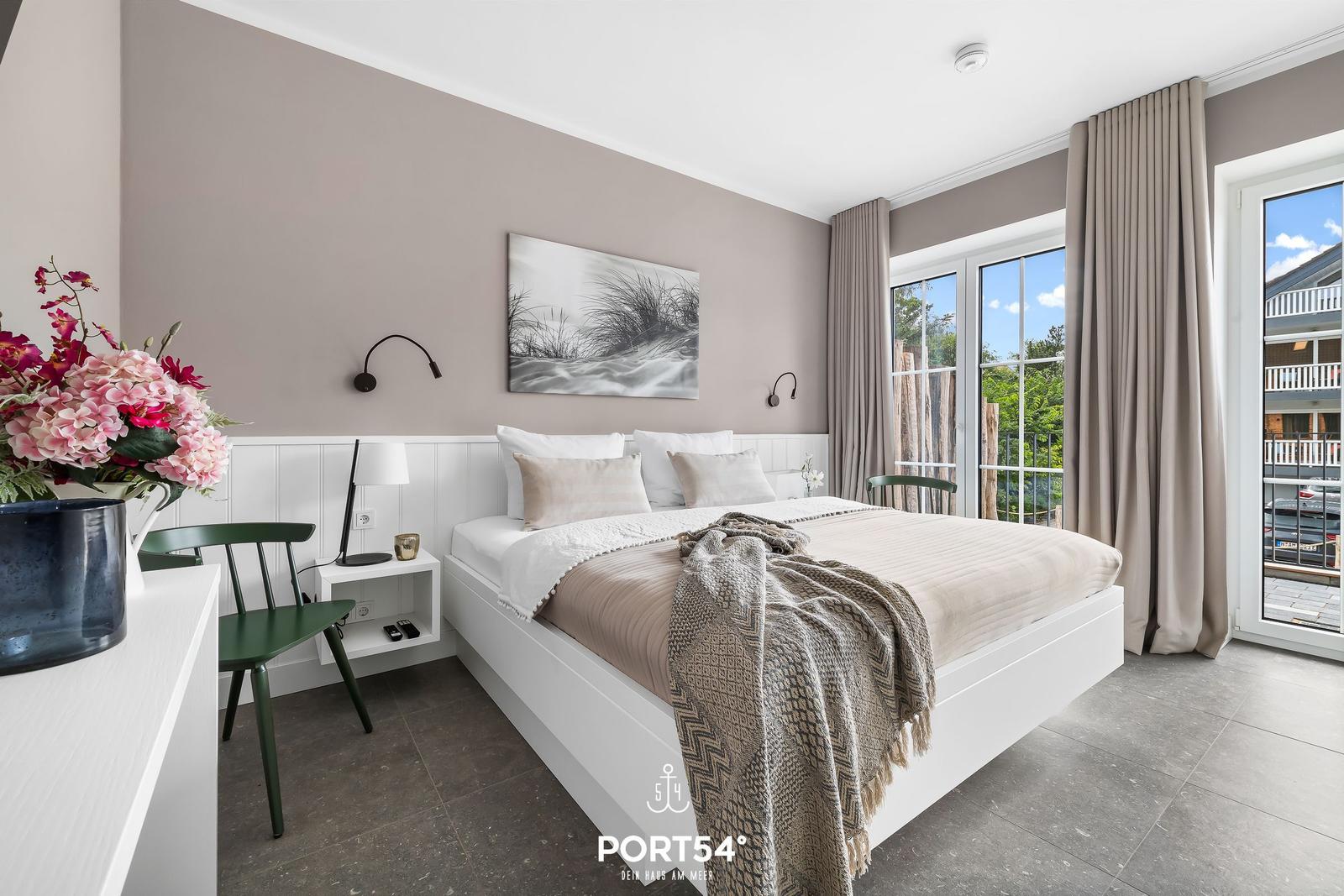 Schlafzimmer mit Bett, Fenster und Blumen