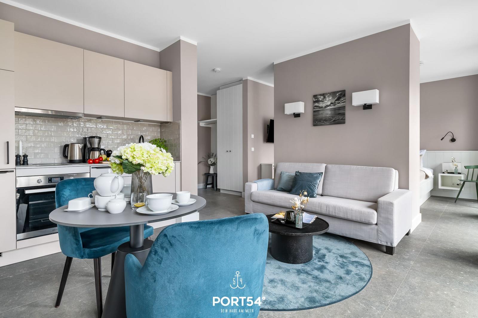 Küche, Essbereich und Wohnzimmer mit Sofa, Tisch und Stühlen.