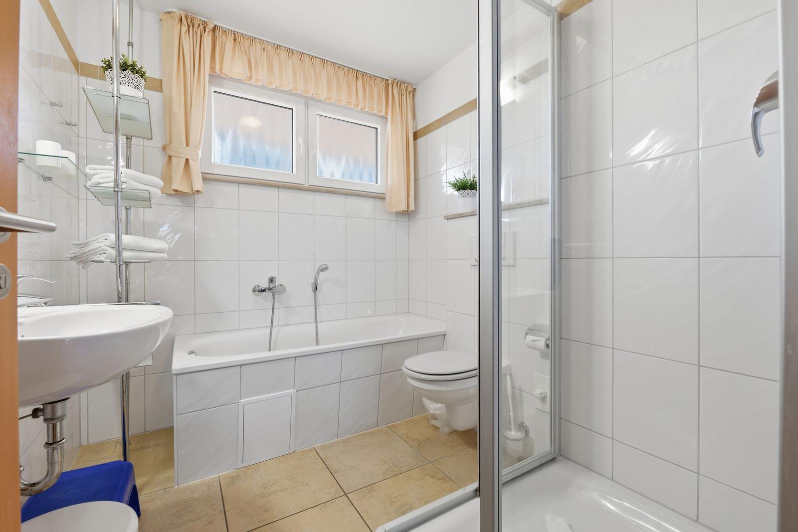 Badezimmer mit Badewanne, Dusche, Toilette und Waschbecken.