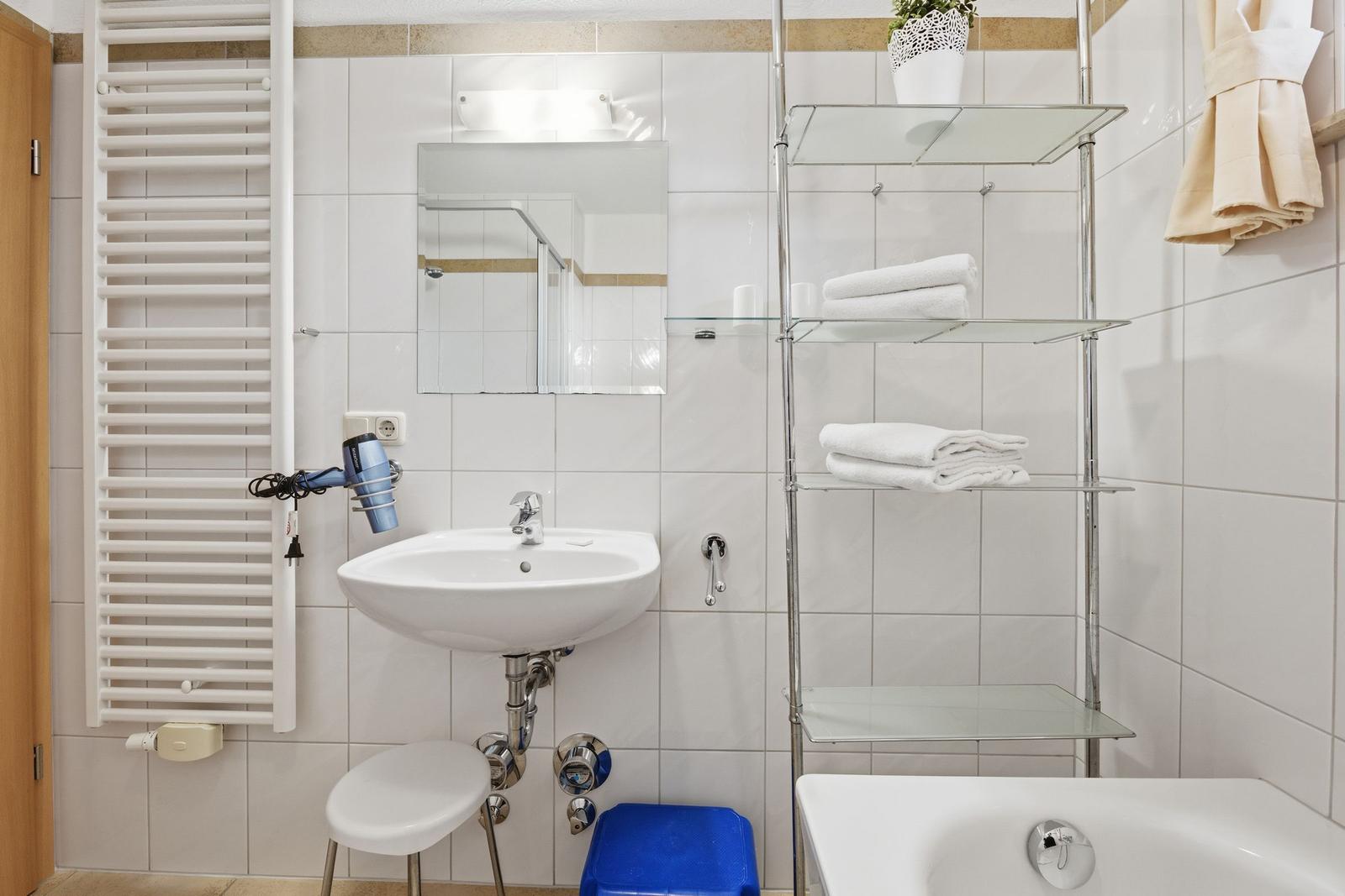 Badezimmer mit Waschbecken, Dusche, Badewanne und Handtuchständer.