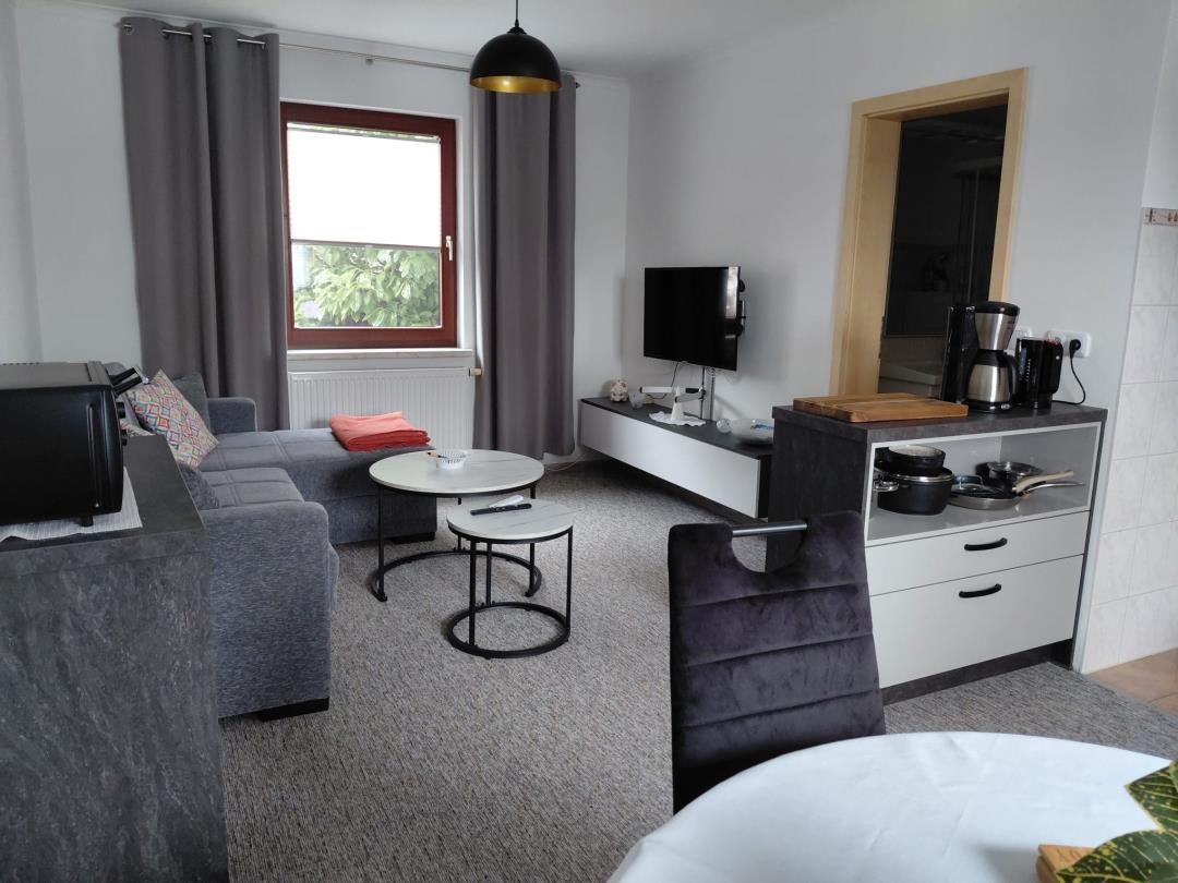 Wohnzimmer mit Sofa, TV und Küchenzeile