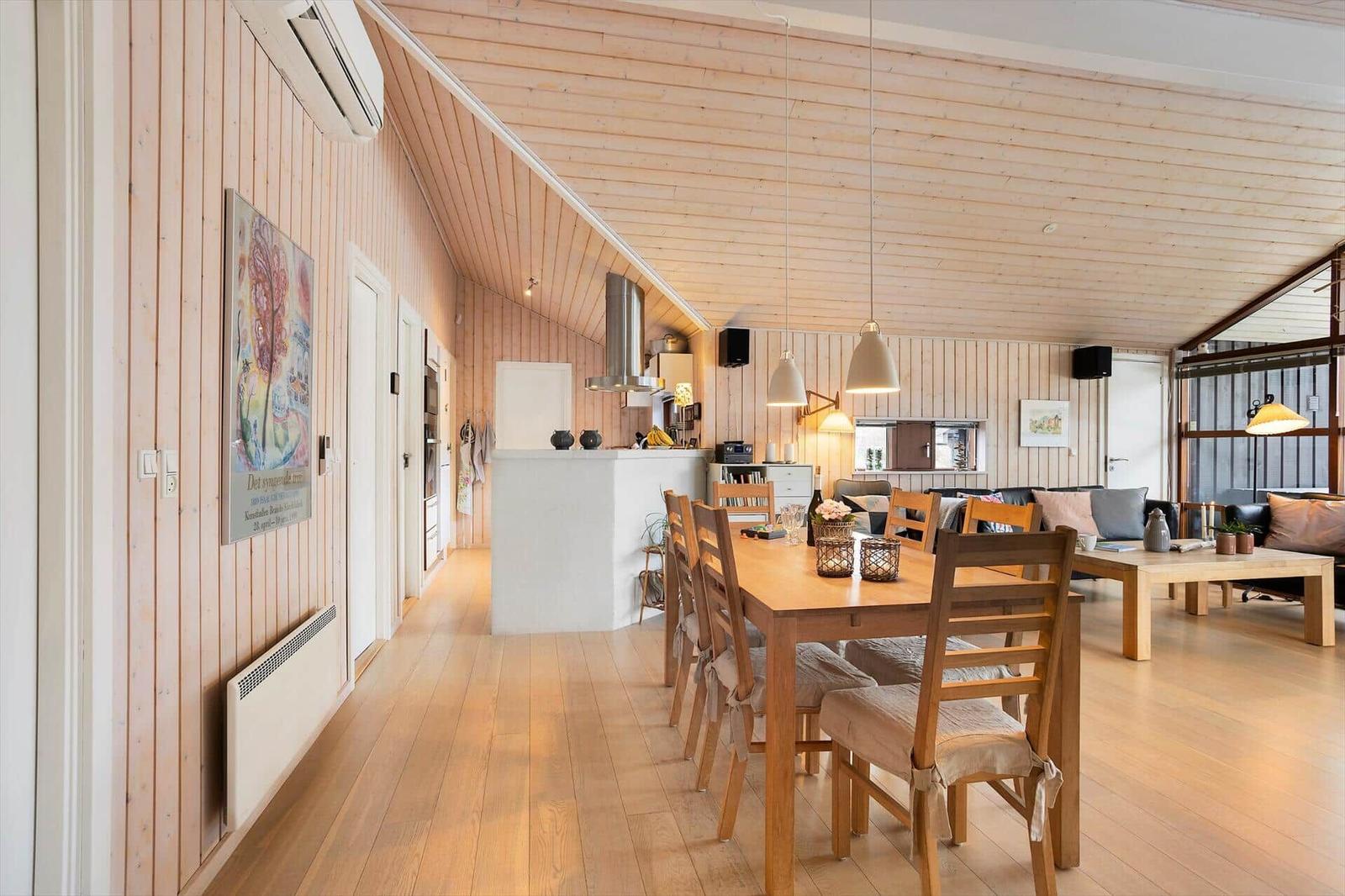 Living area with dining and kitchen under wooden ceiling