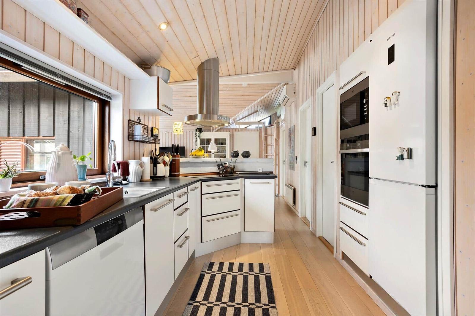 Kitchen with white cabinets, stainless steel stove, and wooden floor.