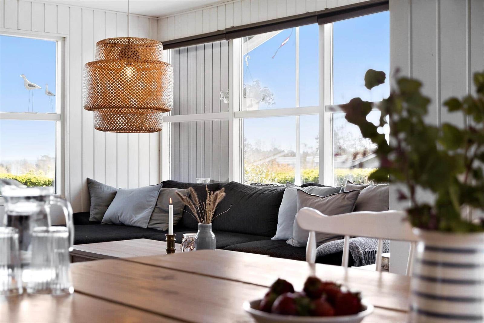 Living room with large windows, sofa, and dining table.