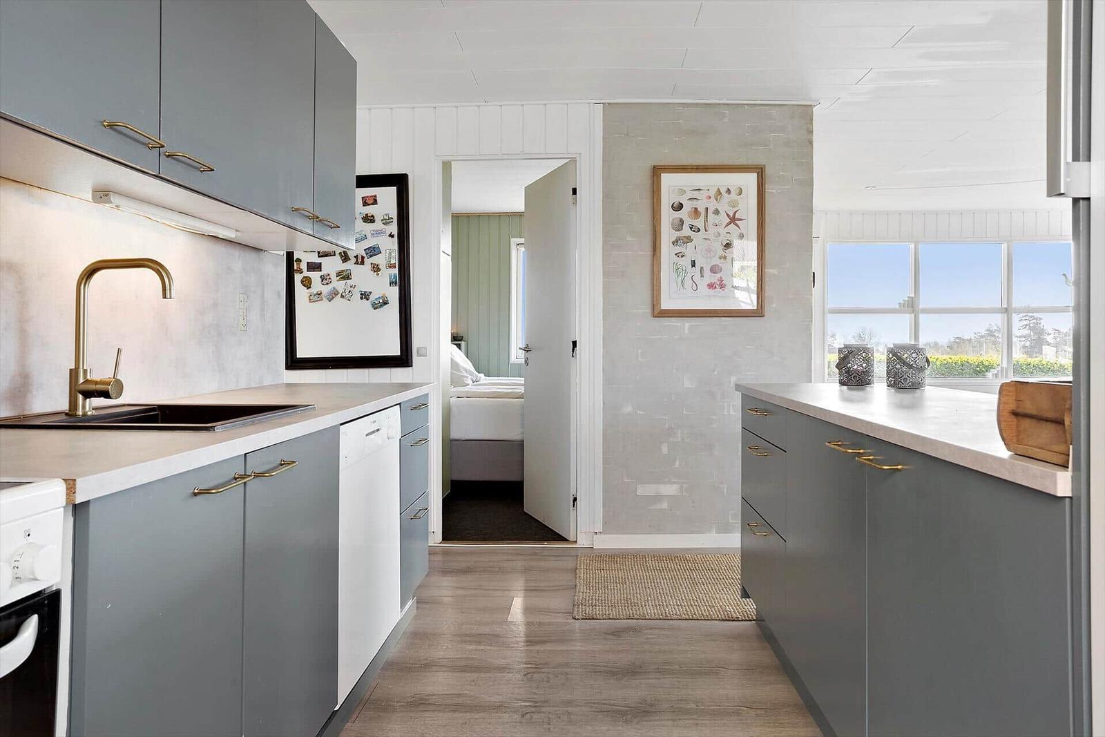 Kitchen with gray cabinets and view into bedroom