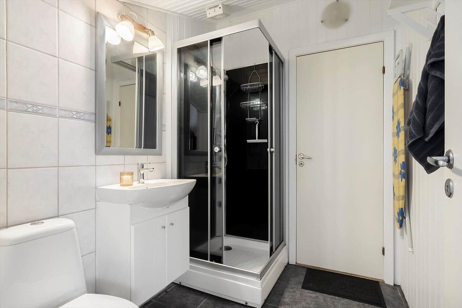 Badezimmer mit Dusche, Waschbecken und Toilette.