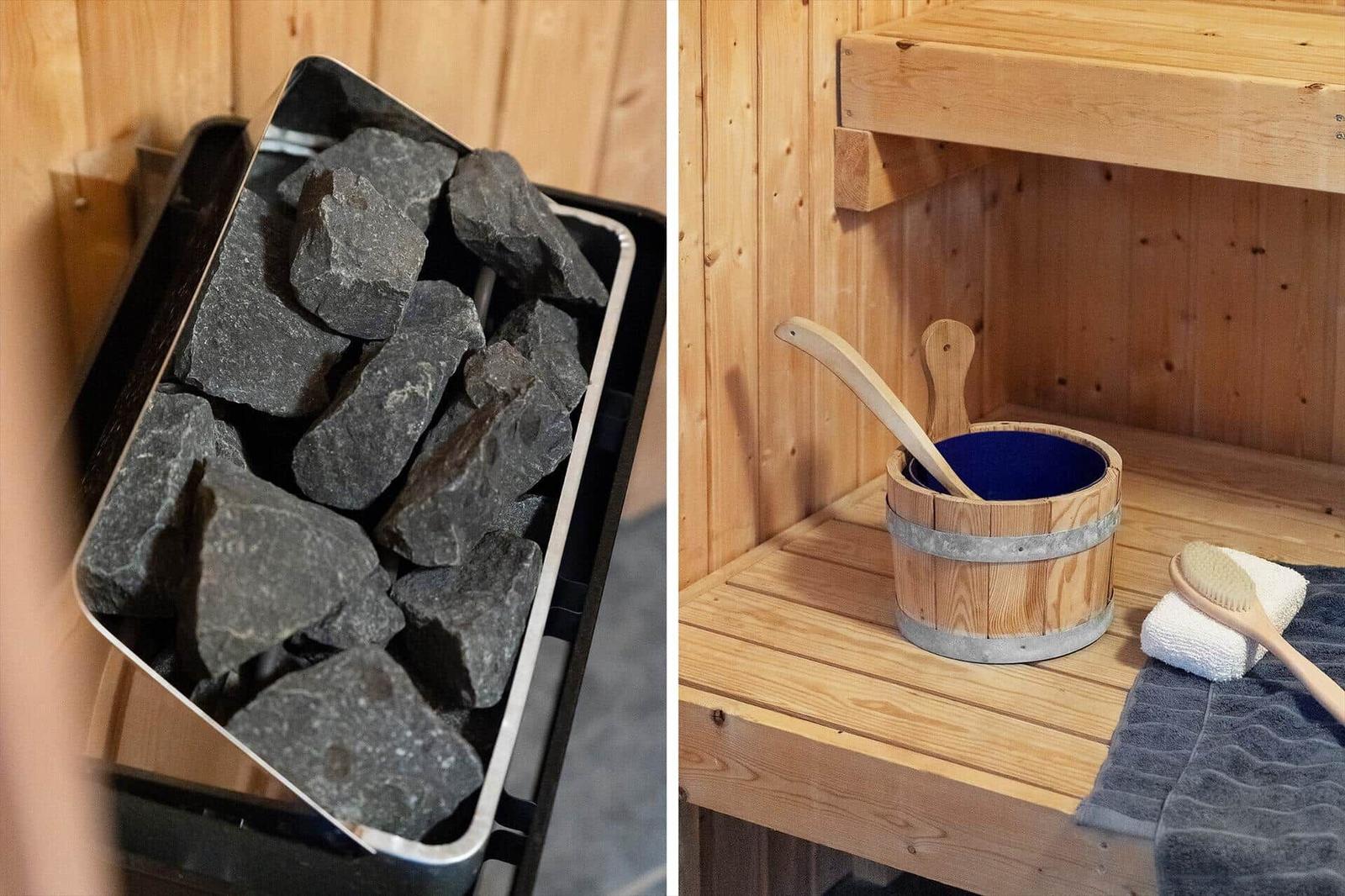 Sauna mit Holzbank, Eimer und Bürste. Links: Steinblock zur Wärmegenerierung.