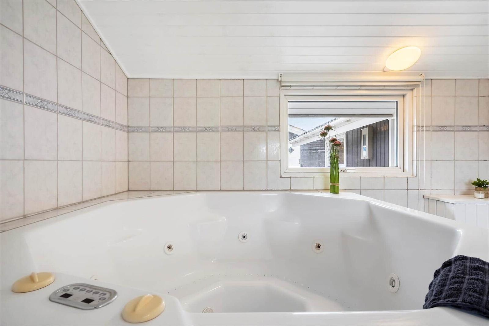 Whirlpool-Bad mit Fenster und Blumen