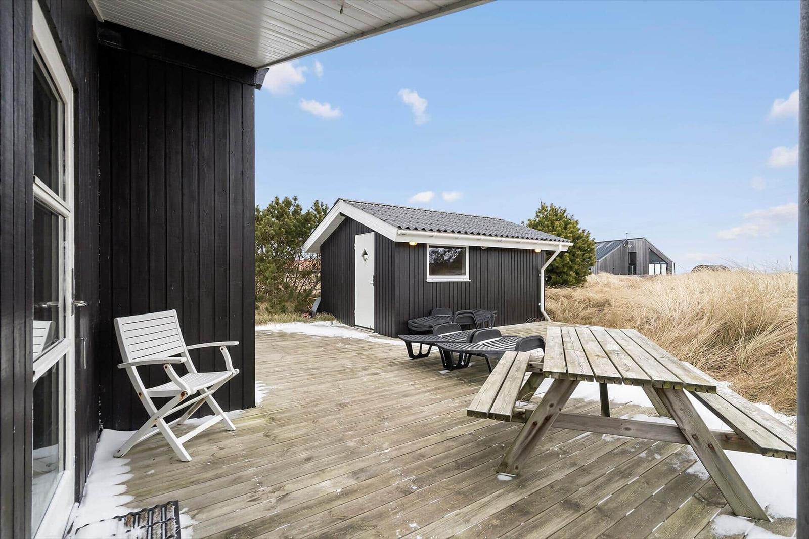 Terrasse mit Tisch, Stühlen und Blick auf Strandhaus