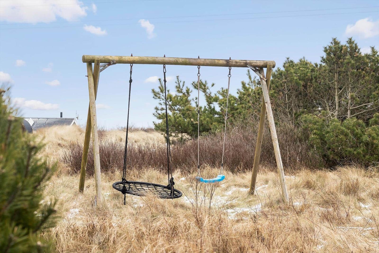 Holzschaukel mit zwei Sitzplätzen im Gras