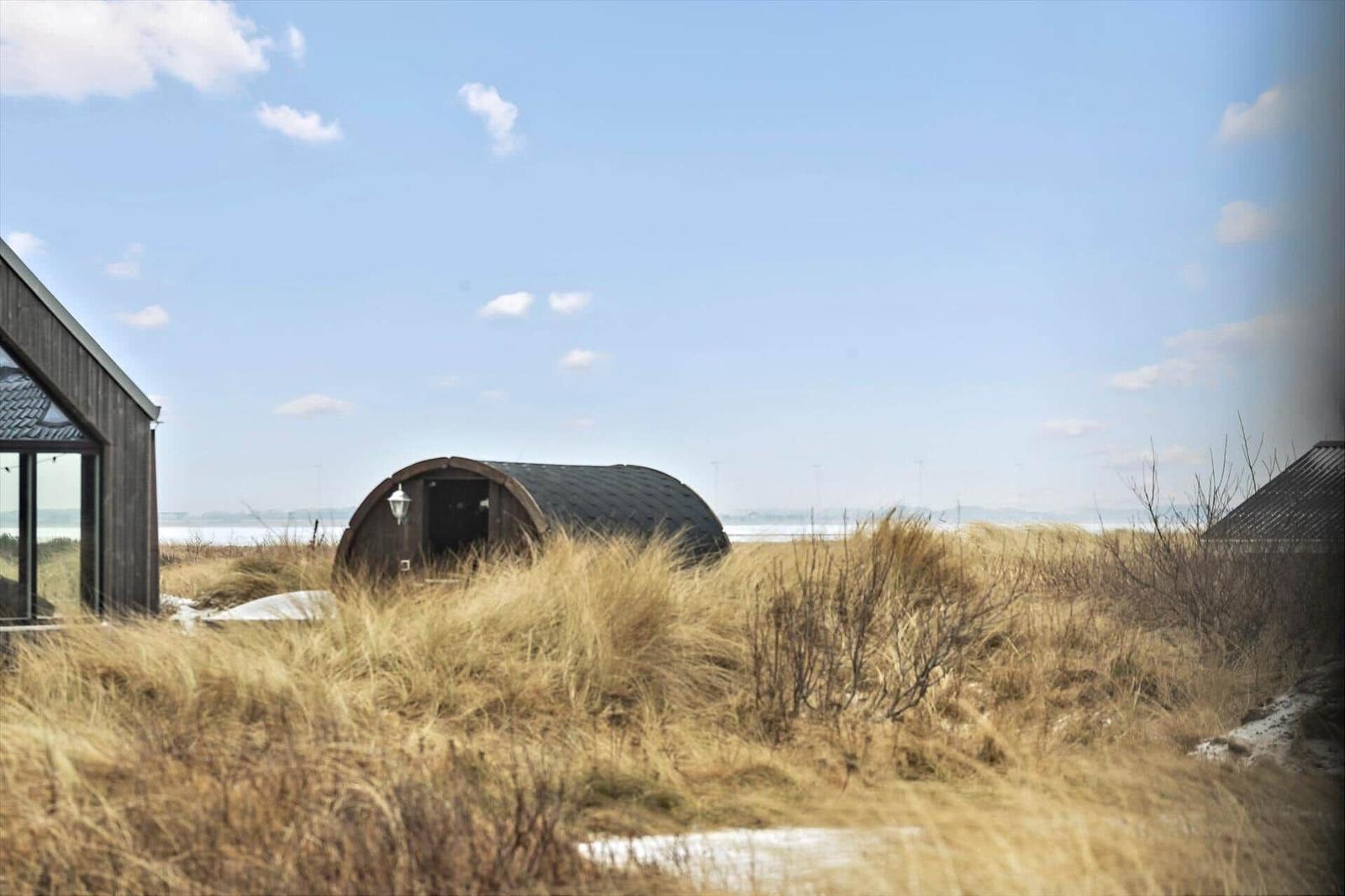 Dorfhaus mit runden Holzhaus im Strandbereich