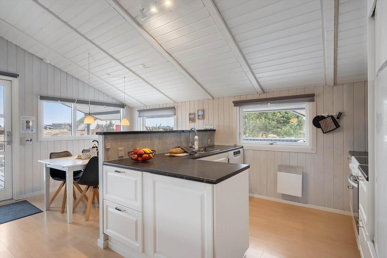 Küche mit Essbereich, Fenstern und Holzboden.