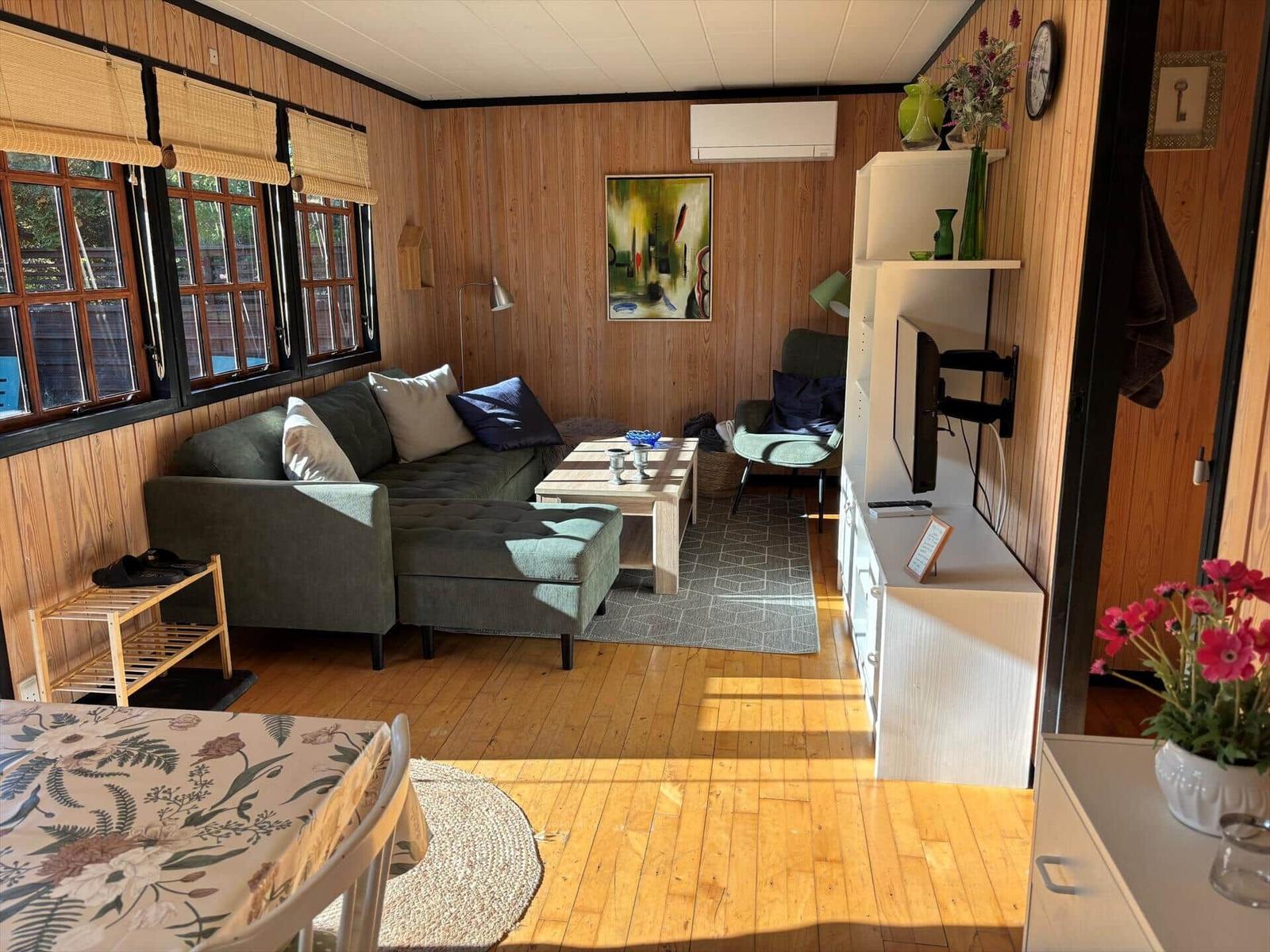 Living room with sofa, coffee table, and TV mounted on the wall.