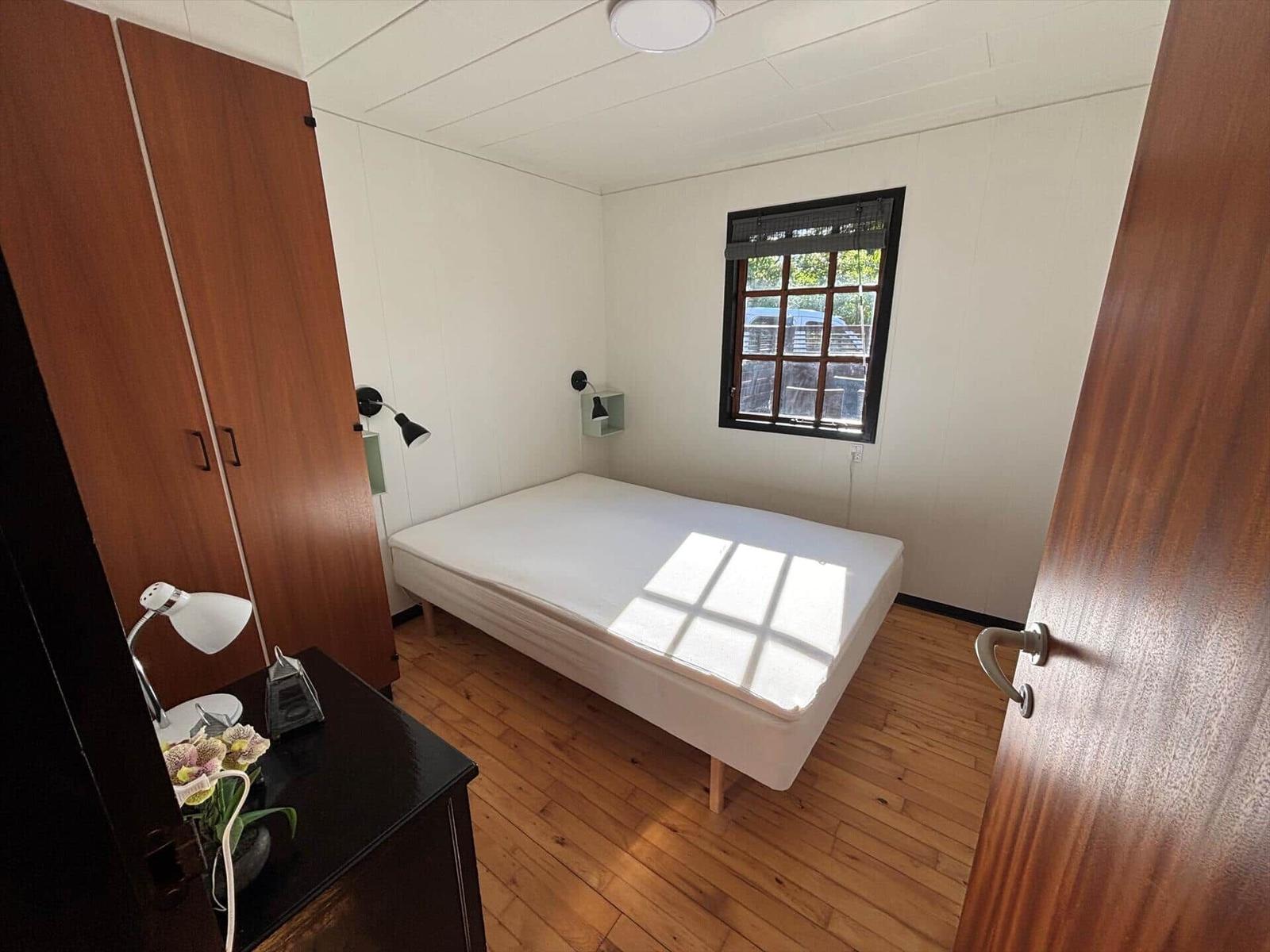 Bedroom with bed, wardrobe, and window