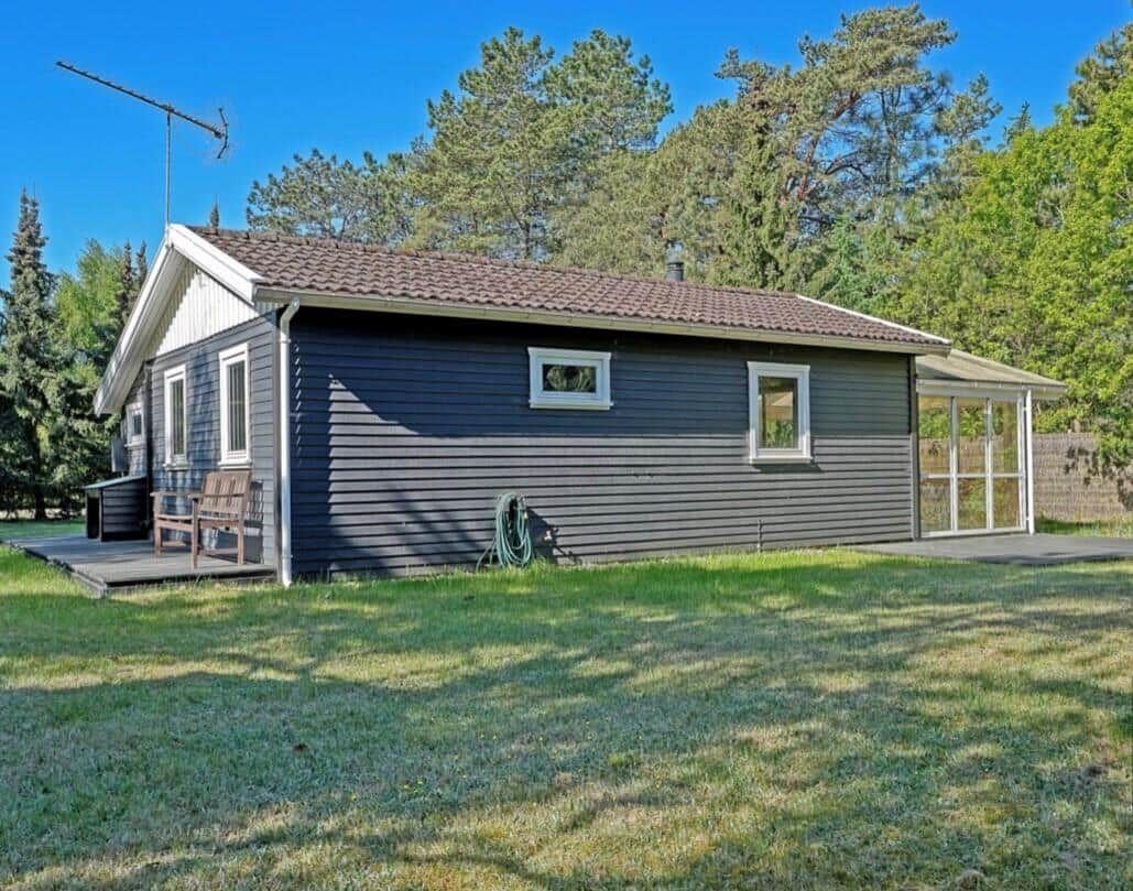 A house with gray siding, white windows, and a garden.
