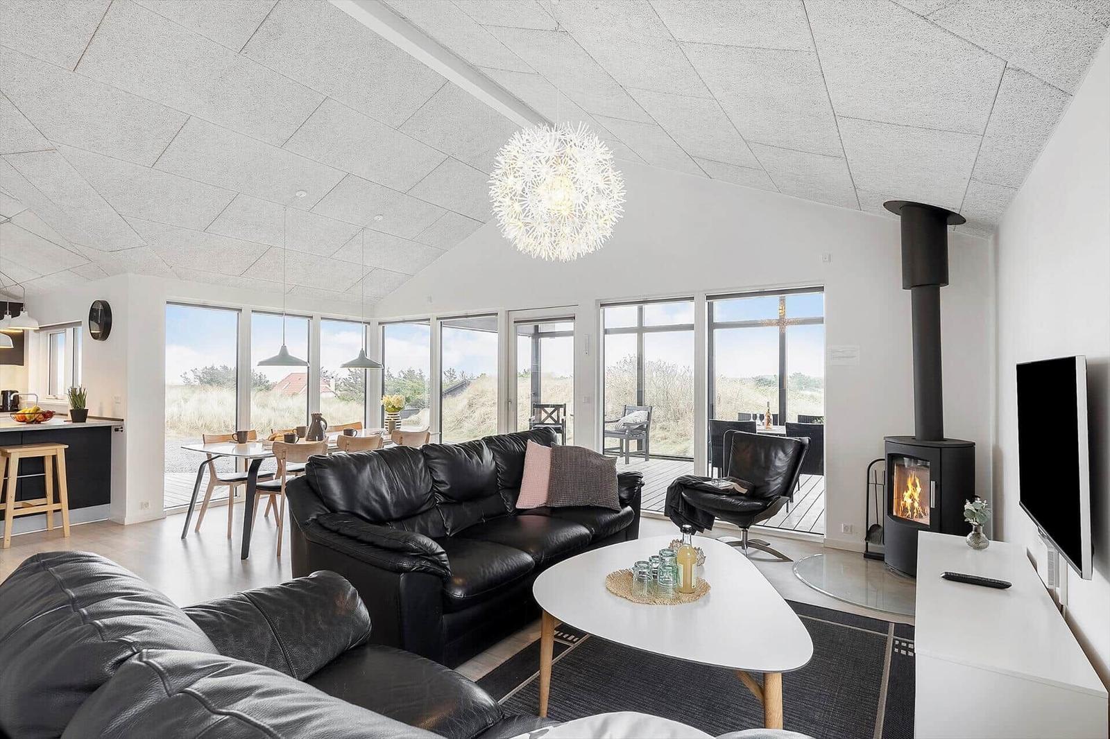 Wohnbereich mit Sofa, Kamin und großem Fensterblick