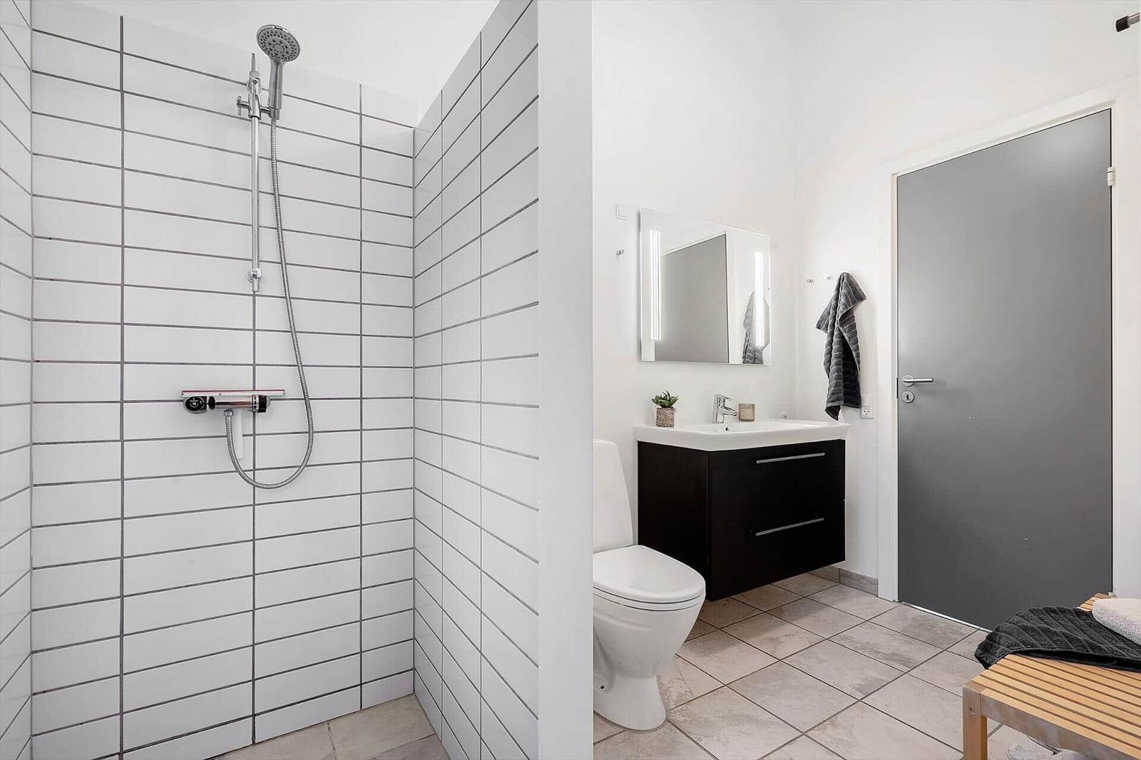 Badezimmer mit Dusche, Waschbecken und Toilette.