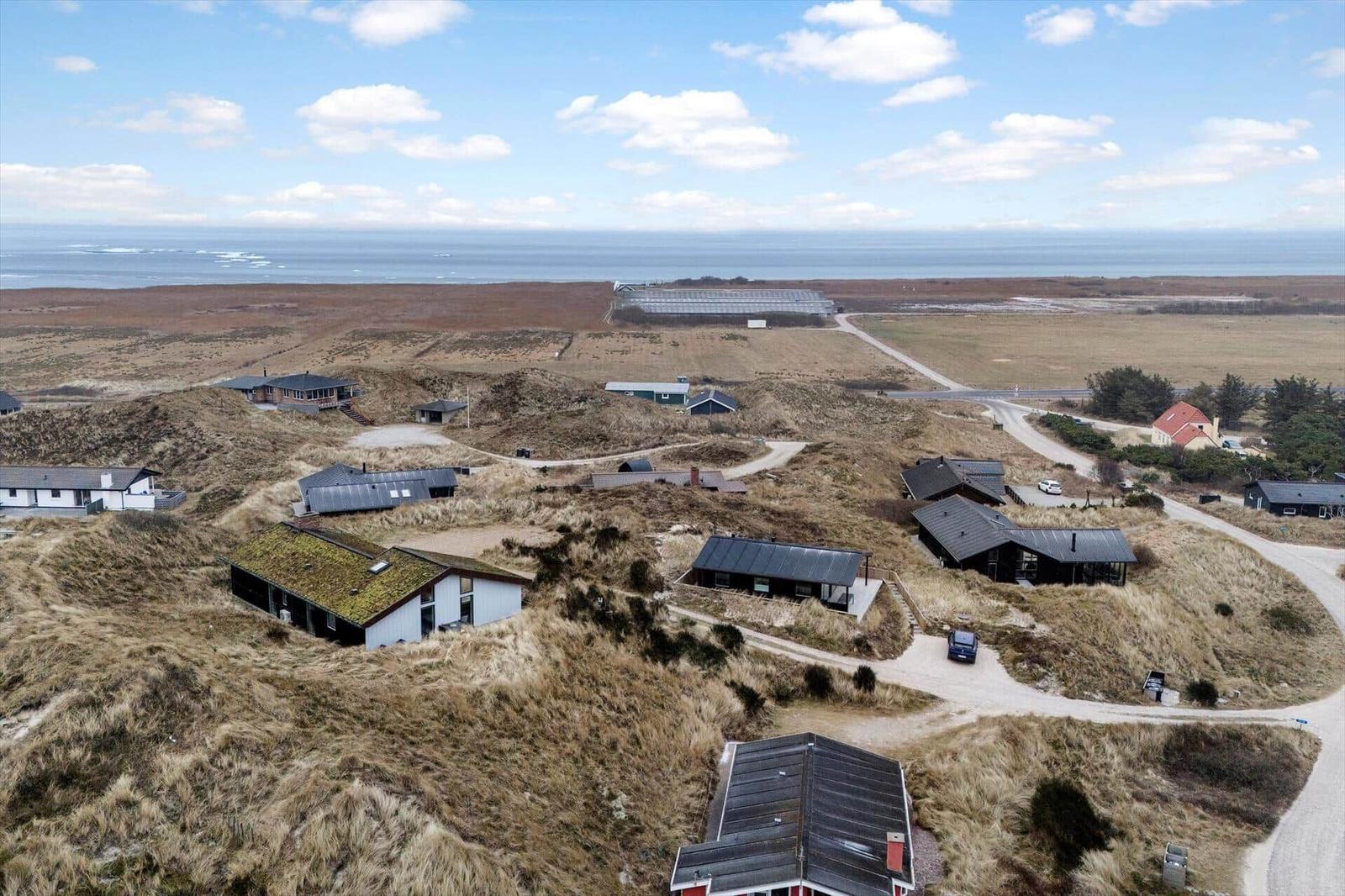 Aussicht auf Strand und Dünen mit mehreren Ferienhäusern