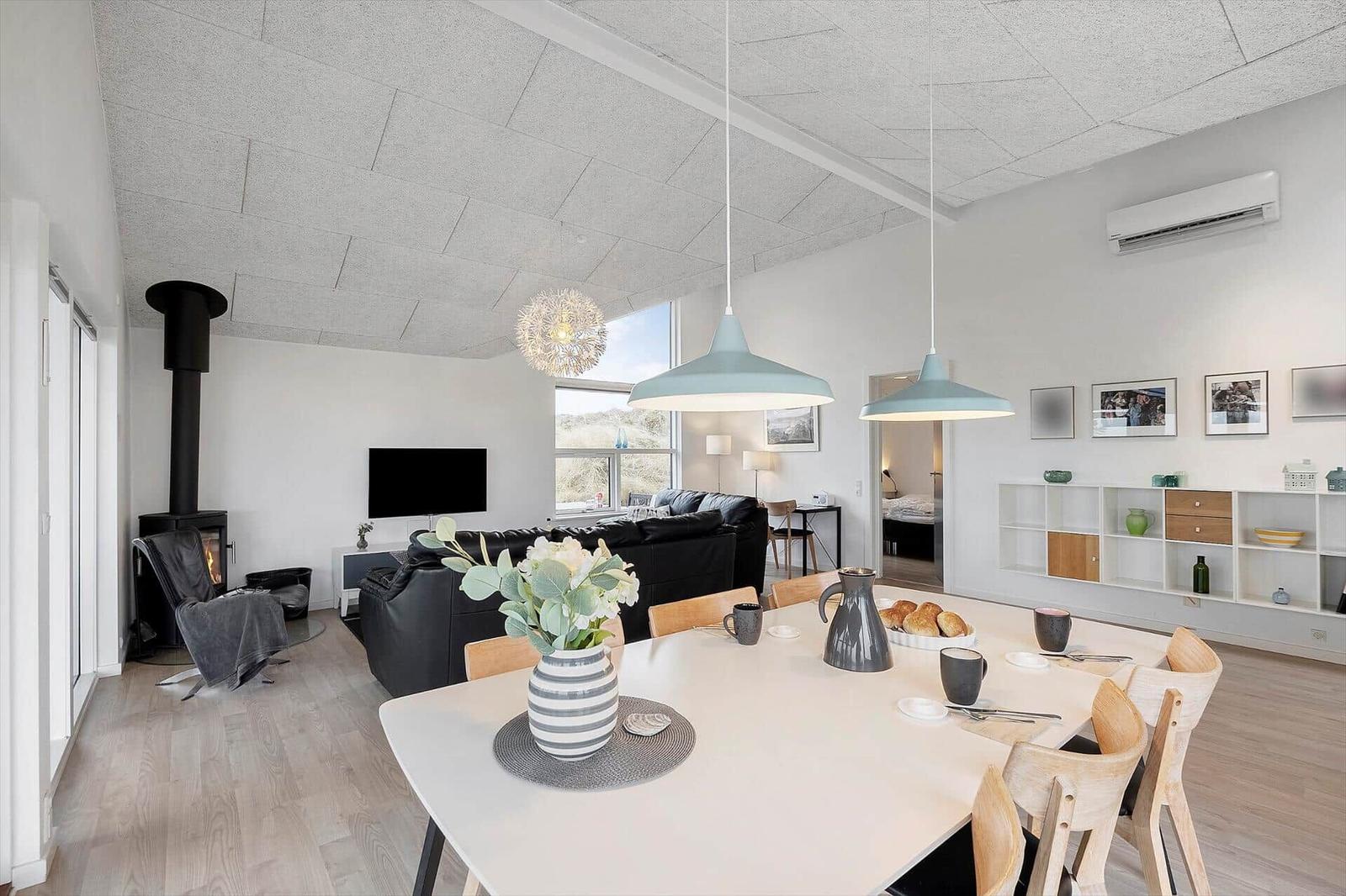 Wohn- und Essbereich mit Esstisch, Sofa, Kamin und Deckenventilator.