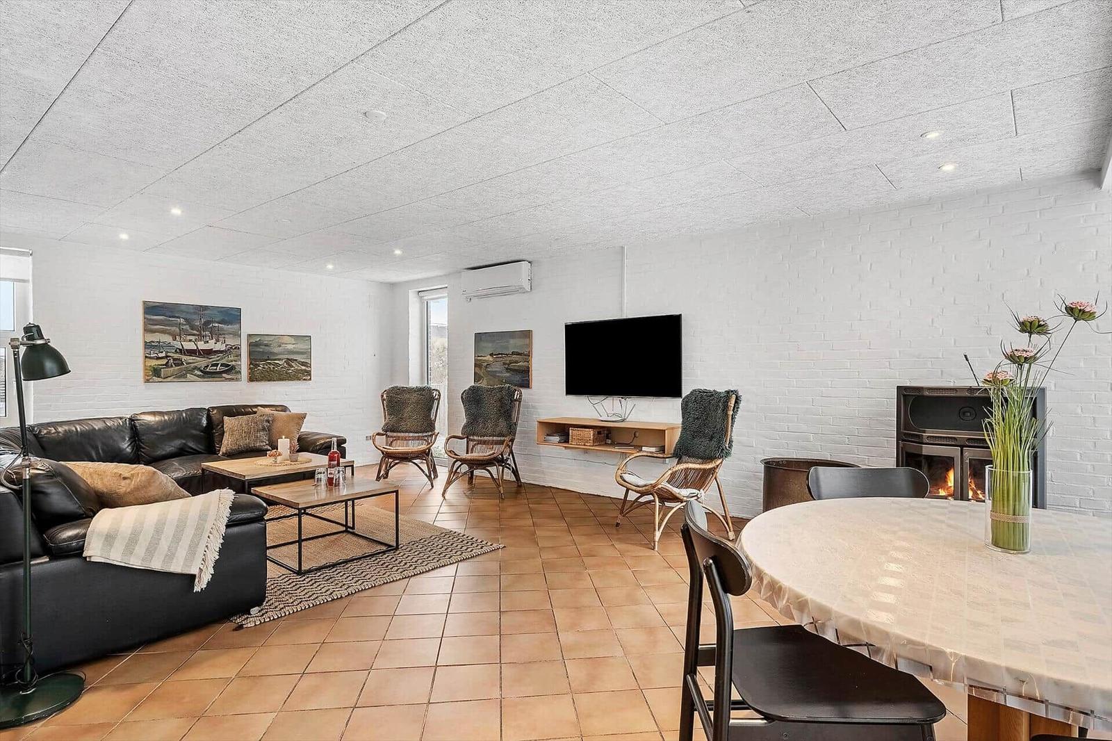 Wohn- und Essbereich mit Sofa, Fernseher und Kamin.