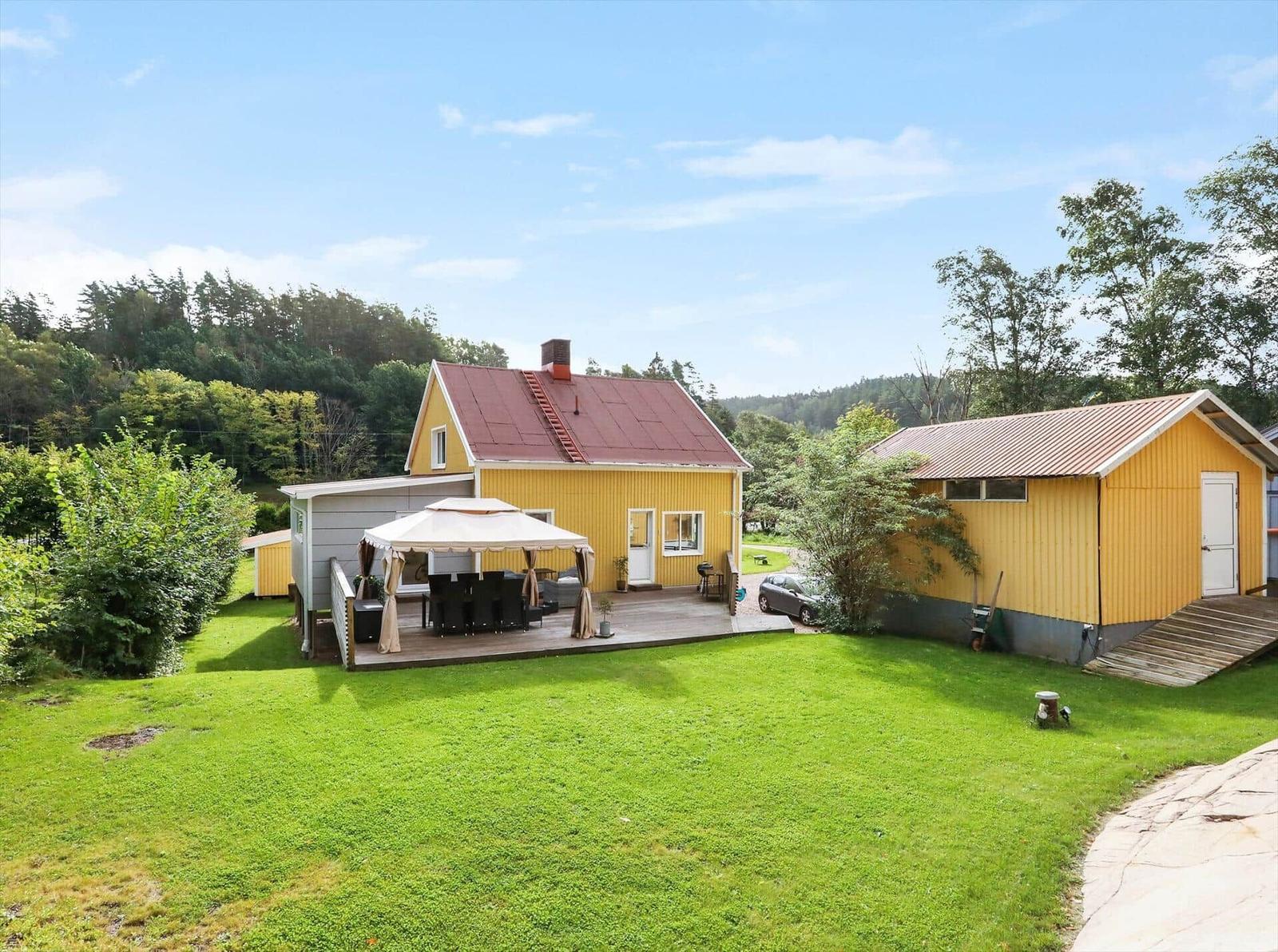 Gelbes Haus mit Terrasse und Garten. Grill und Sonnenschutz vorhanden.