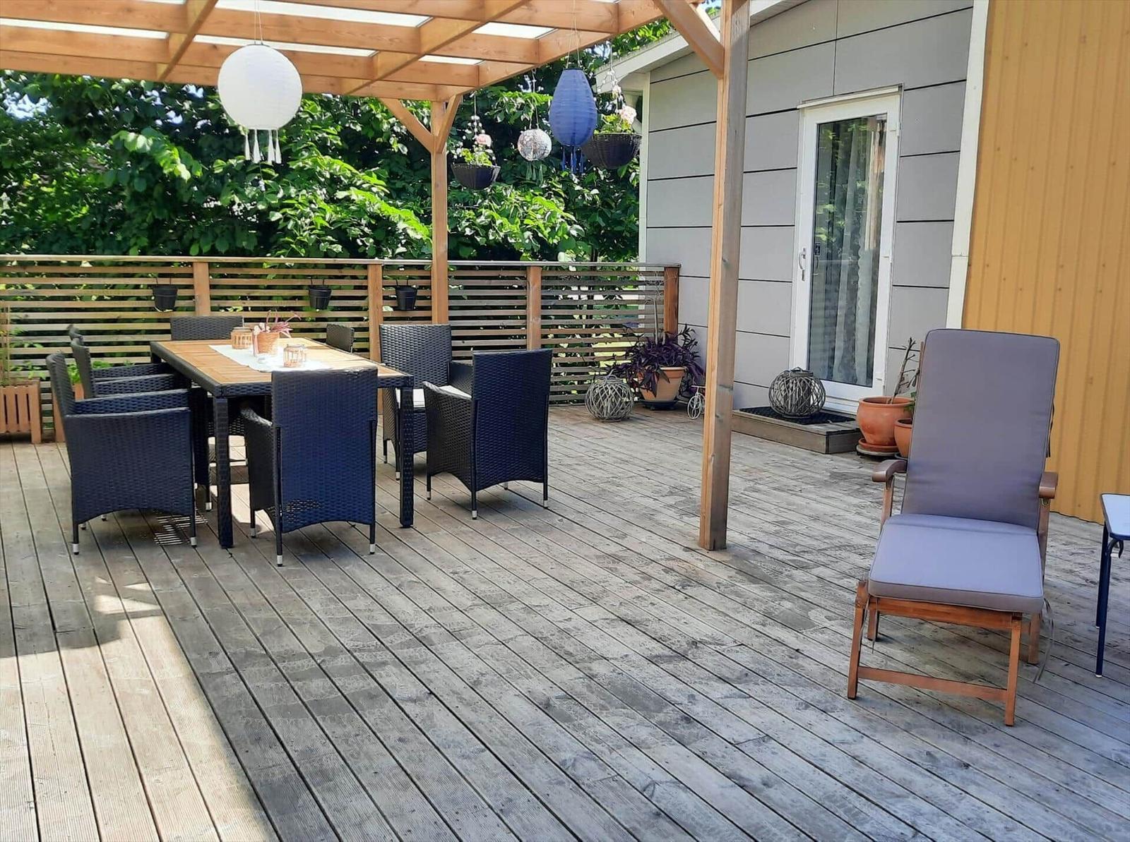 Terrasse mit Holzterrasse, Sitzgruppe und Pavillon mit Hängelampen.