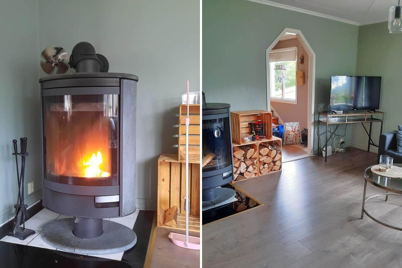 Kaminofen mit brennendem Holz, Holzkisten mit Brennholz und Wohnzimmer mit Fernseher und Couch.
