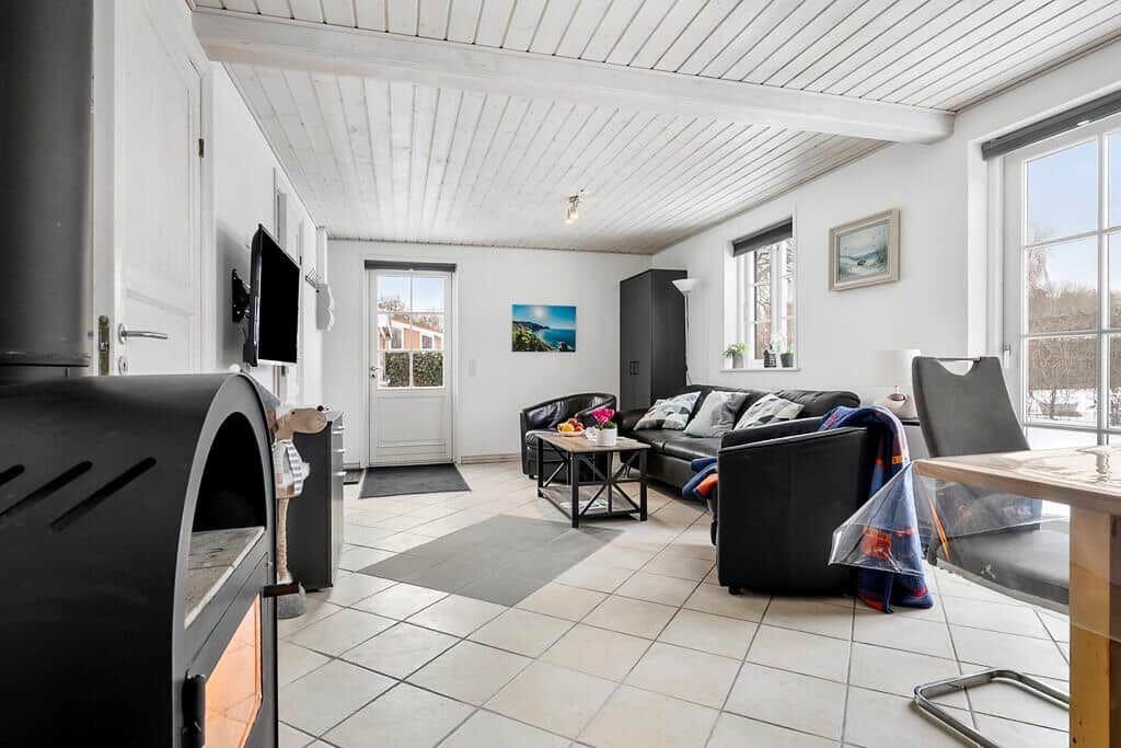 Living room with sofa, fireplace, and large windows.
