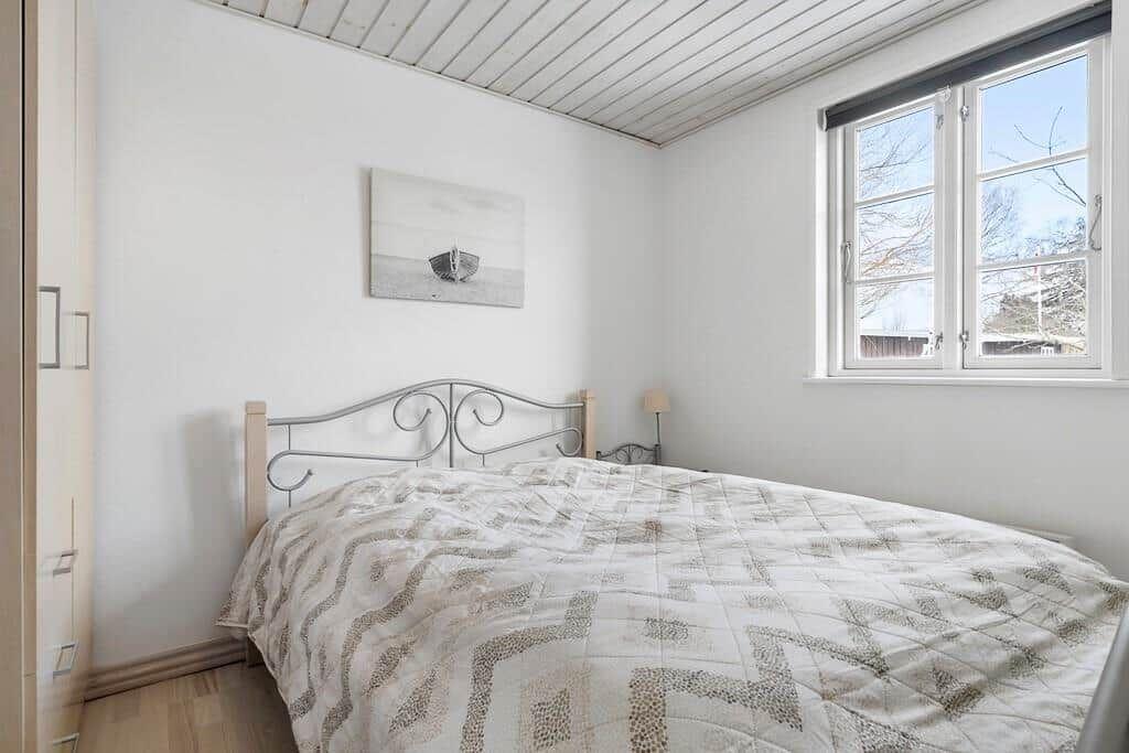 Bedroom with bed, window, and wall art.