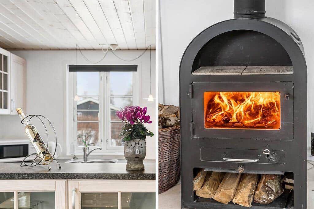 Kitchen with window and wood-burning stove with lit fire.