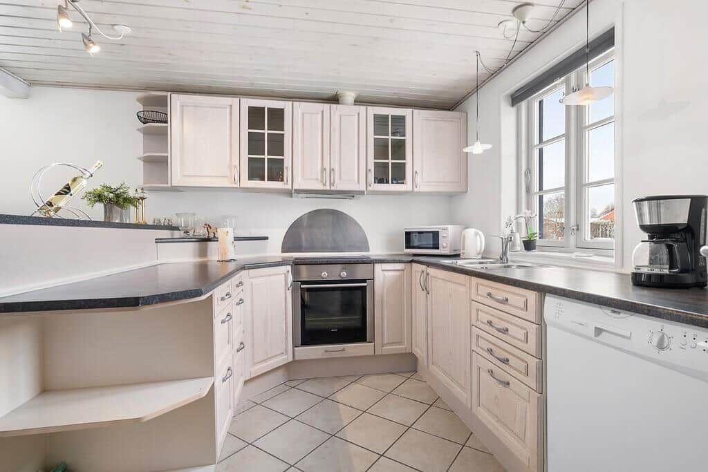 Kitchen with light cabinets, dark countertop, and window