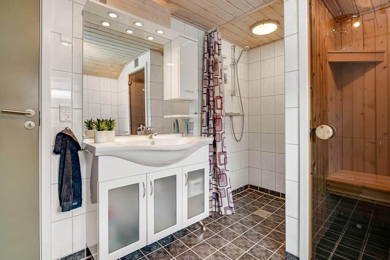 Badezimmer mit Dusche, Waschbecken und Sauna