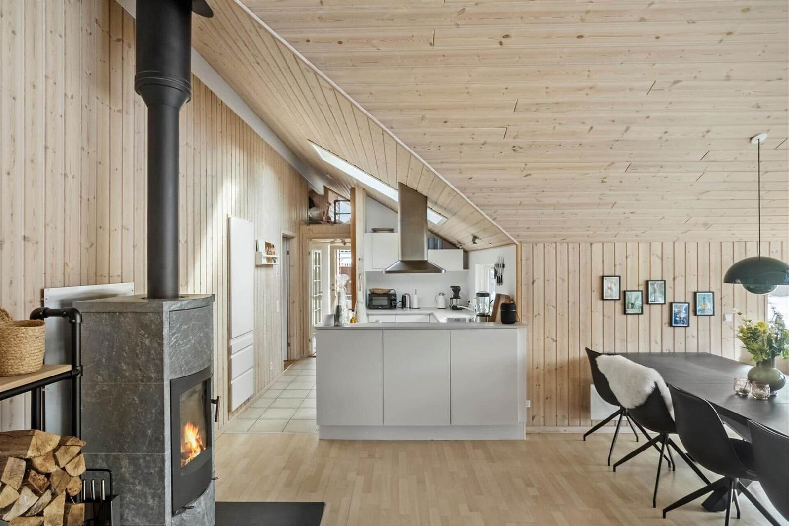 Kitchen with dining area, wood wall, and fireplace