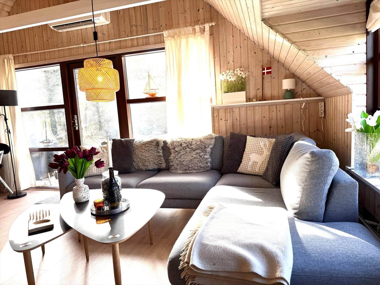 Wohnzimmer mit Sofa, Couchtisch und Holzwand