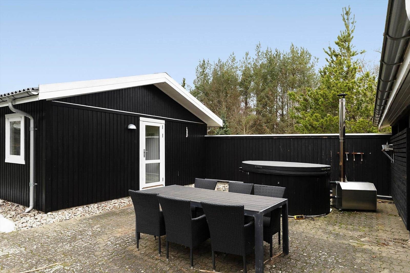 Outdoor area with table, chairs, hot tub, and grill spot