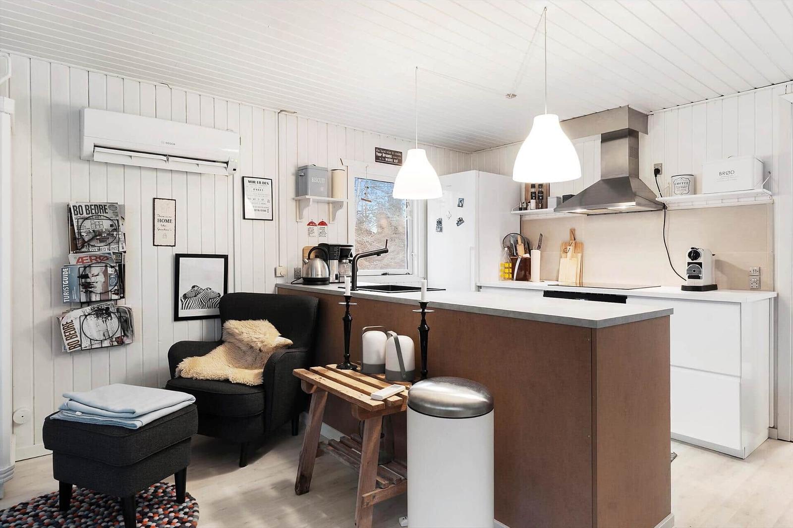 Kitchen with worktop and seating. White walls and wooden elements.