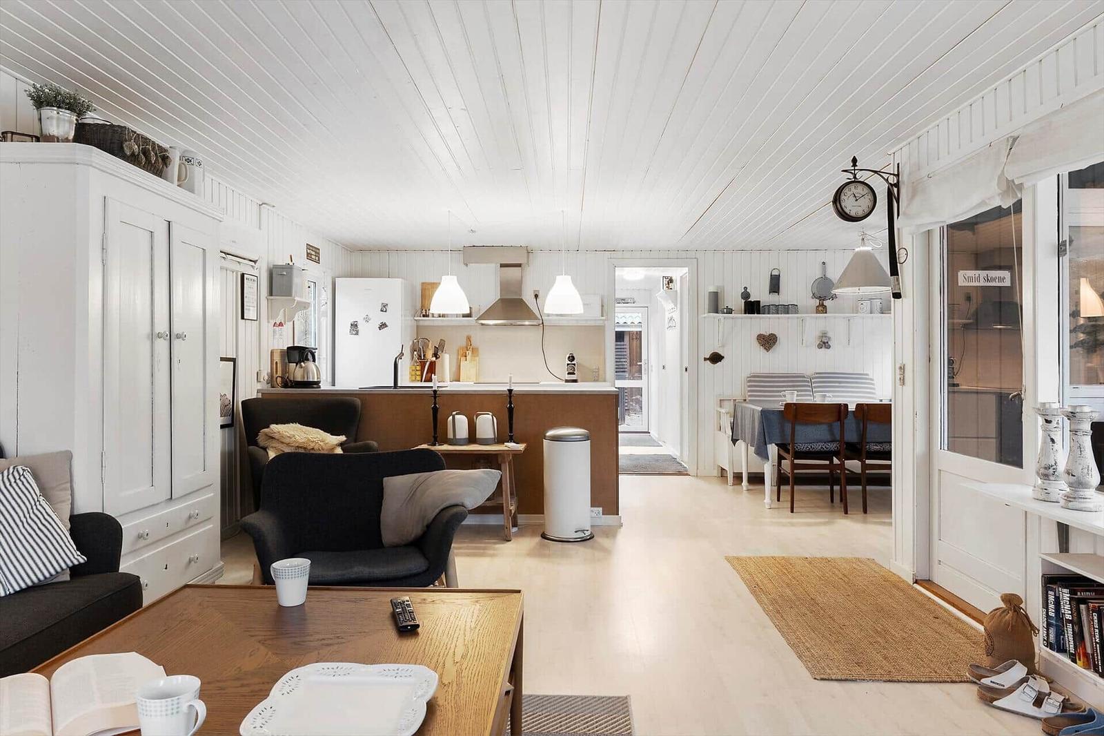 Living kitchen with dining area, white walls, and wooden floor.