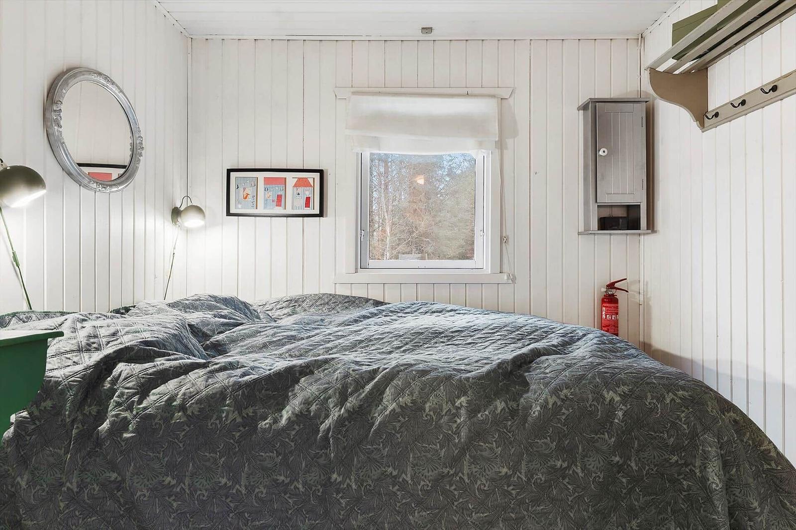 Bedroom with bed, window, and wall decor.