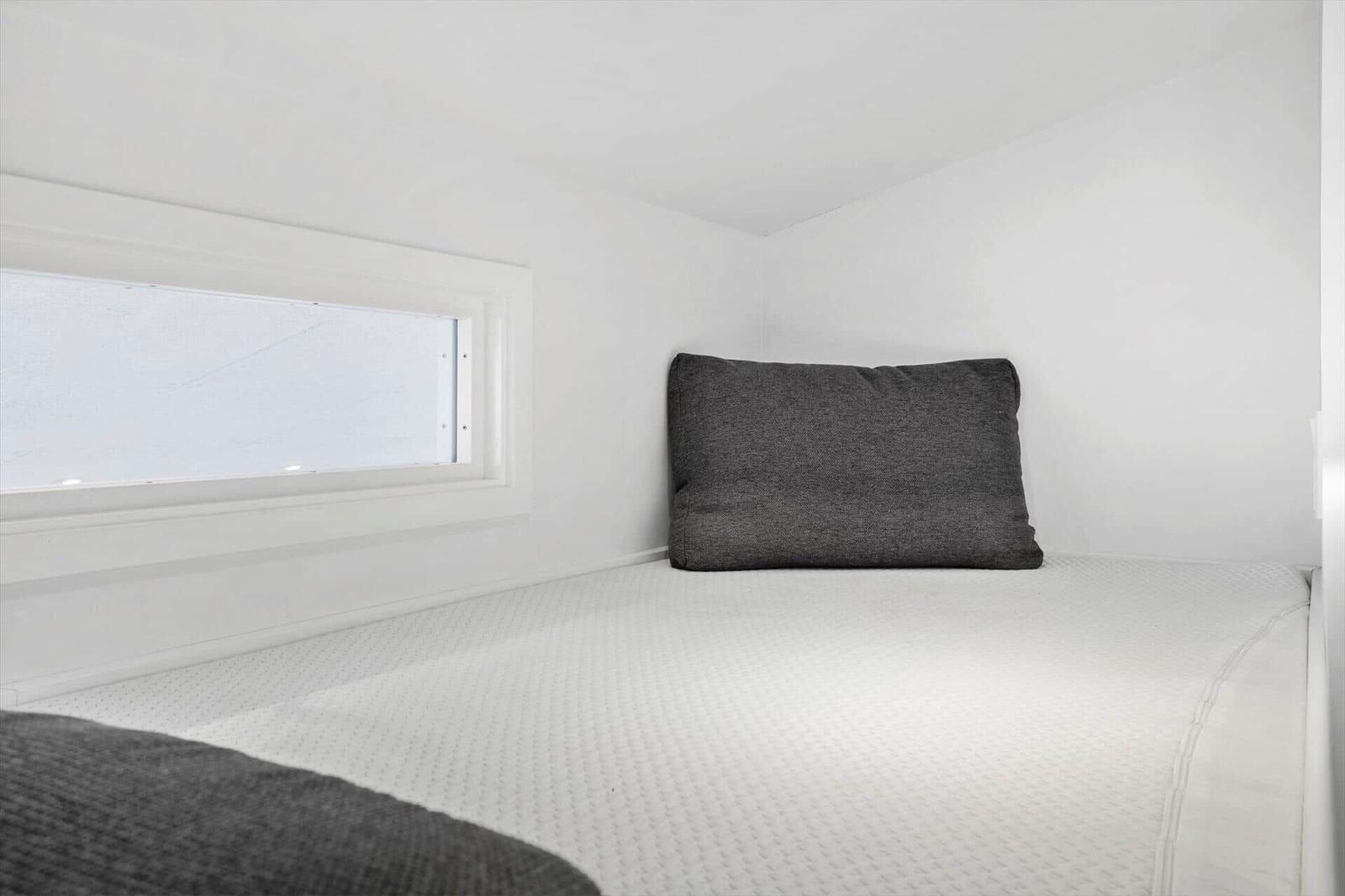 Schlafplatz mit Kissen und Fenster im Schlafzimmer