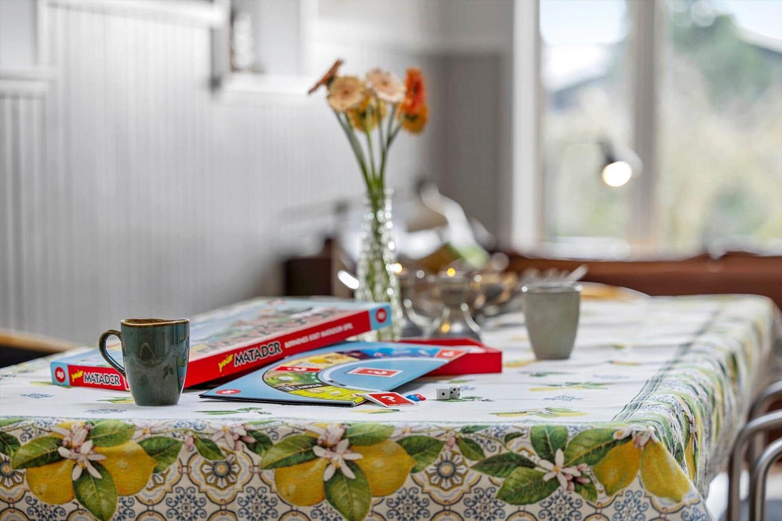Tisch mit Spiel und Tischdecke mit Zitronenmuster.