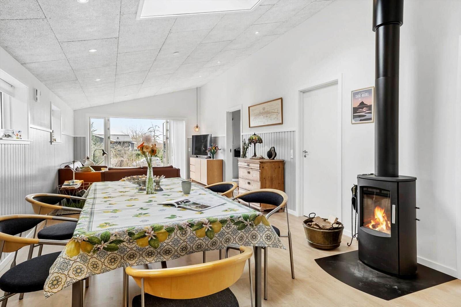 Essbereich mit Tischdecke, Kamin und Sitzgelegenheit. Durchgang zur Küche und Wohnzimmer.