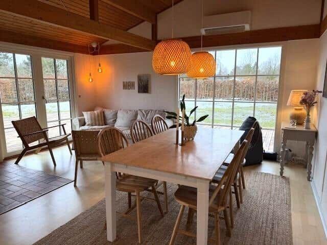 Essbereich mit Holztisch und Stühlen, großes Fenster mit Blick auf Felder