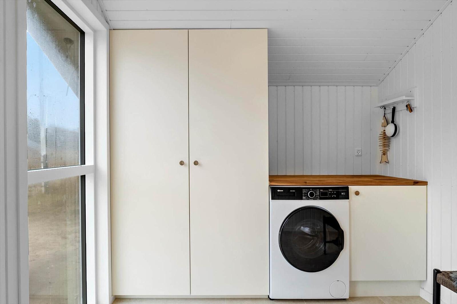 Laundry room with washing machine, closet, and window