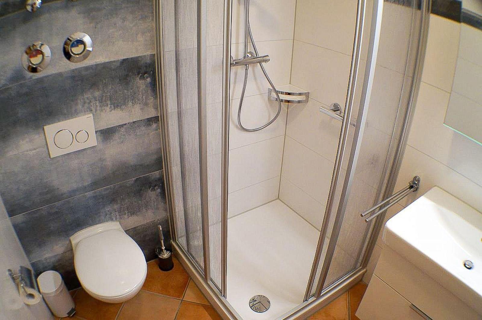 Badezimmer mit Dusche, Toilette und Waschbecken